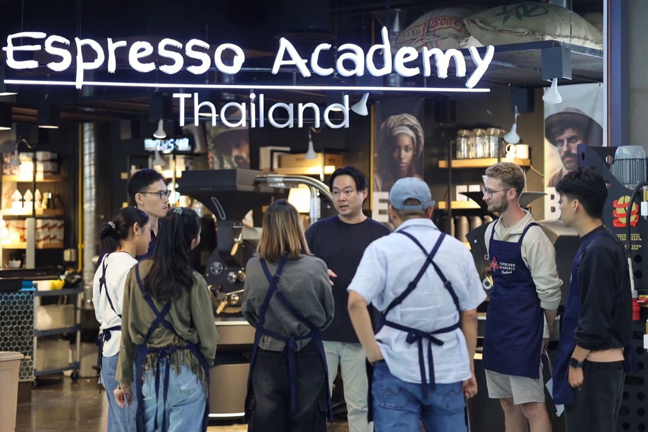 Natt teaching a group beside the roasting machines at Espresso Academic Thailand