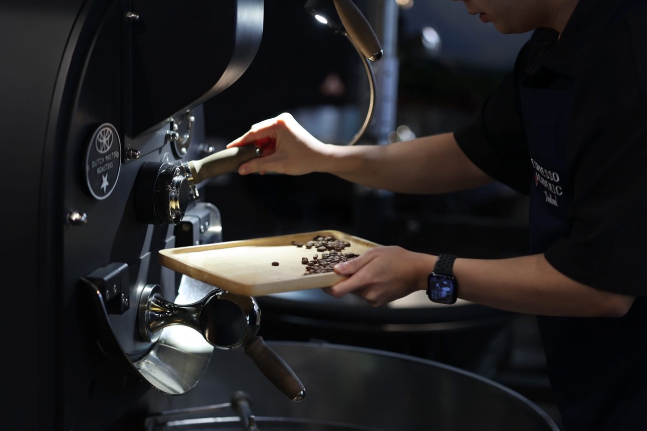 A student checking coffee beans at a Dutch Master roaster
