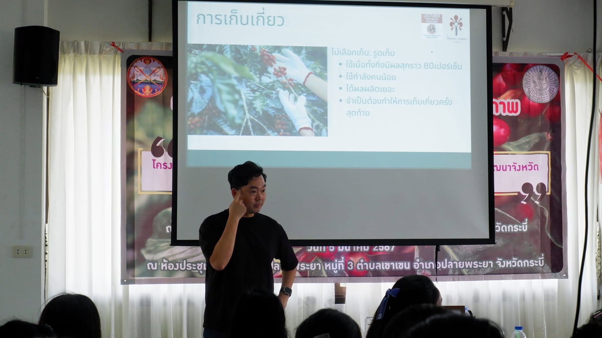 Natt teaching coffee producers in Plai Phraya, Krabi, with students seen from behind