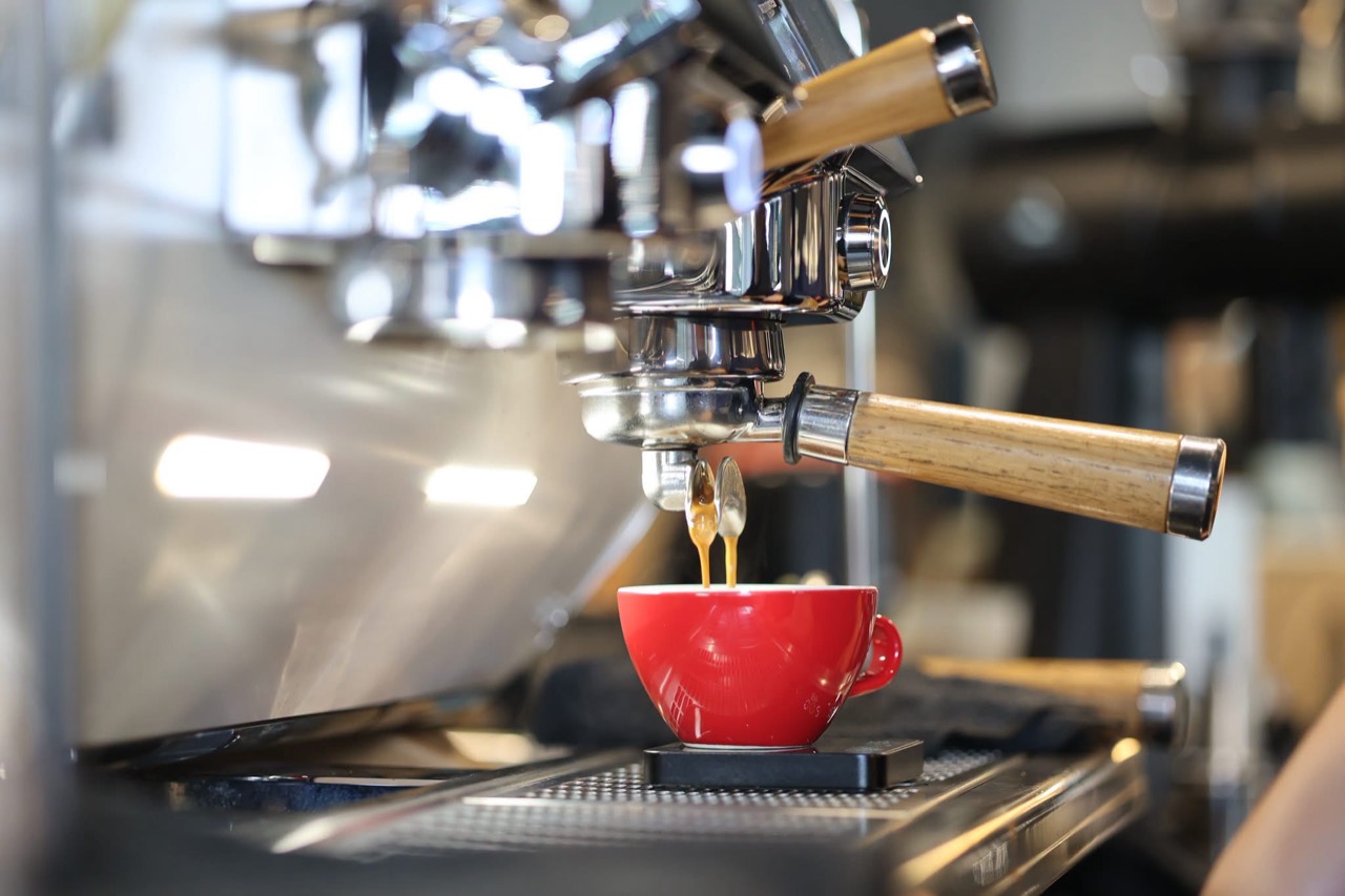 Espresso pouring into a red cup