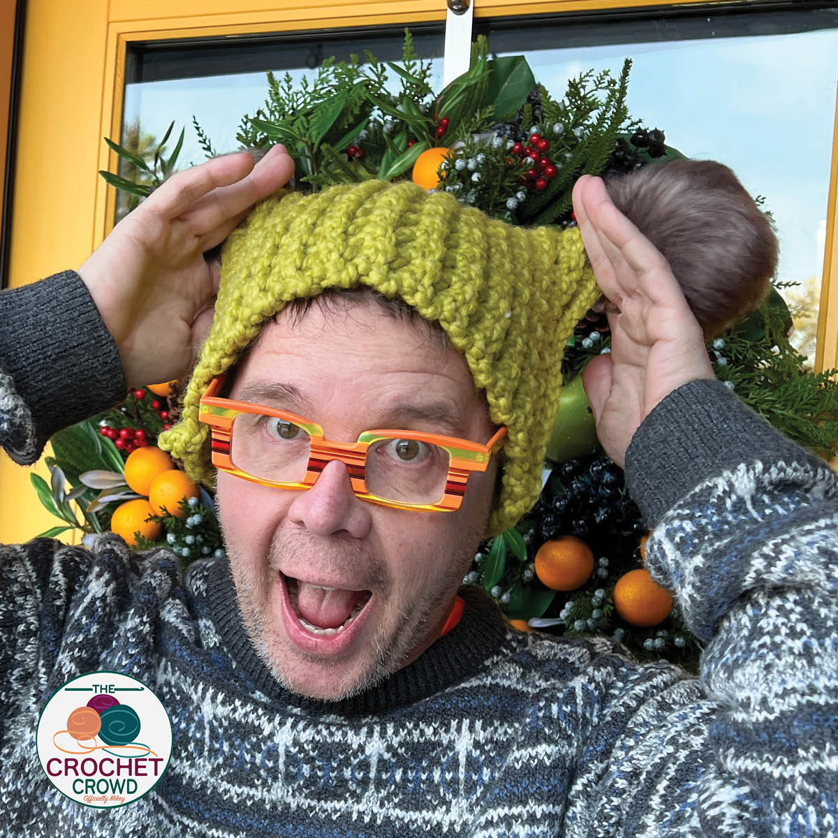 Man wearing acidic colour cat ears crochet hat.