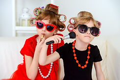 Two funny little girls with curlers in t