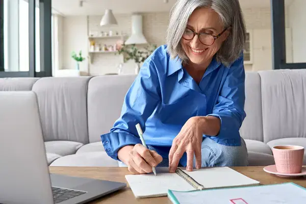 woman taking notes at webinar