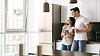 Happy couple smiling and drinking coffee in kitchen after professional tile and grout cleaning service in Lake Country BC