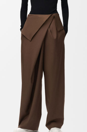 Trousers made from 100% Italian lightweight fluid wool featuring an asymmetric draped front with a flap at the waist