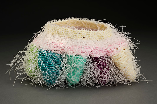 A contemporary vessel by Sausalito basket artist, Emily Dvorin, made from deconstructed mesh bath poofs and security ties.