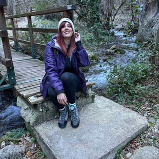 ragazza seduta su un ponticello di legno nel bosco