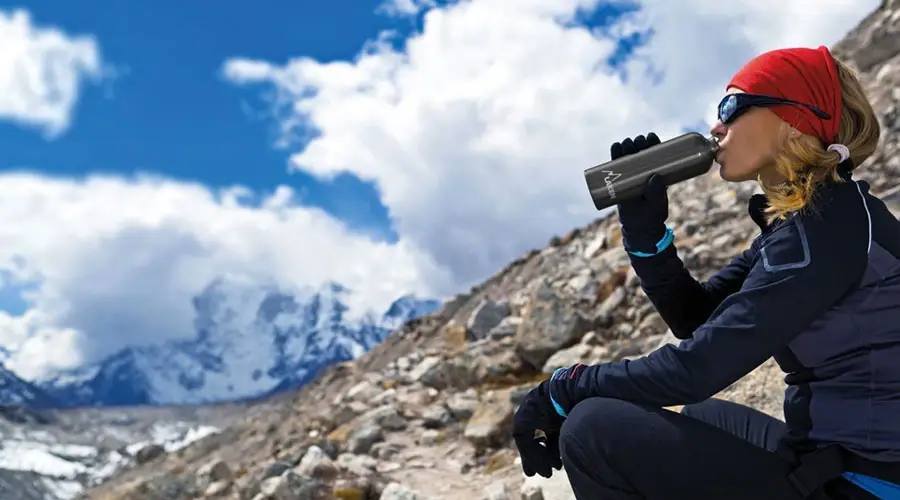 ragazza che beve in montagna