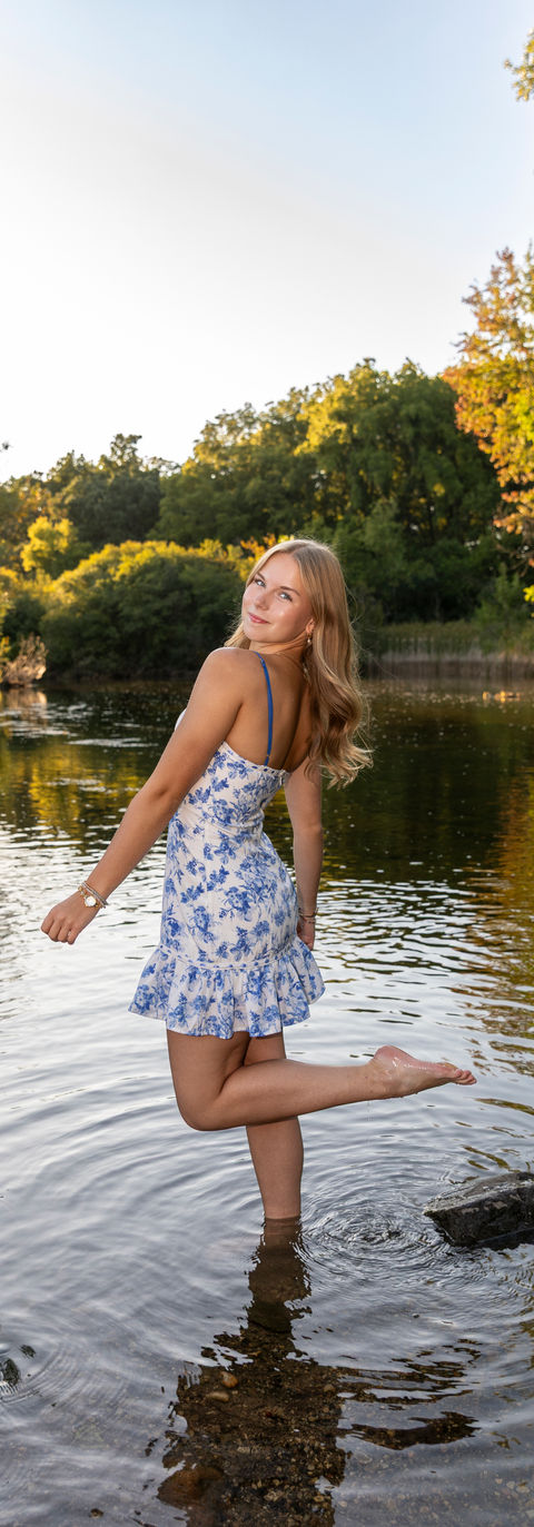 high school girl kicking up water in river