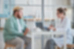 overweight man sitting and talking to his doctor