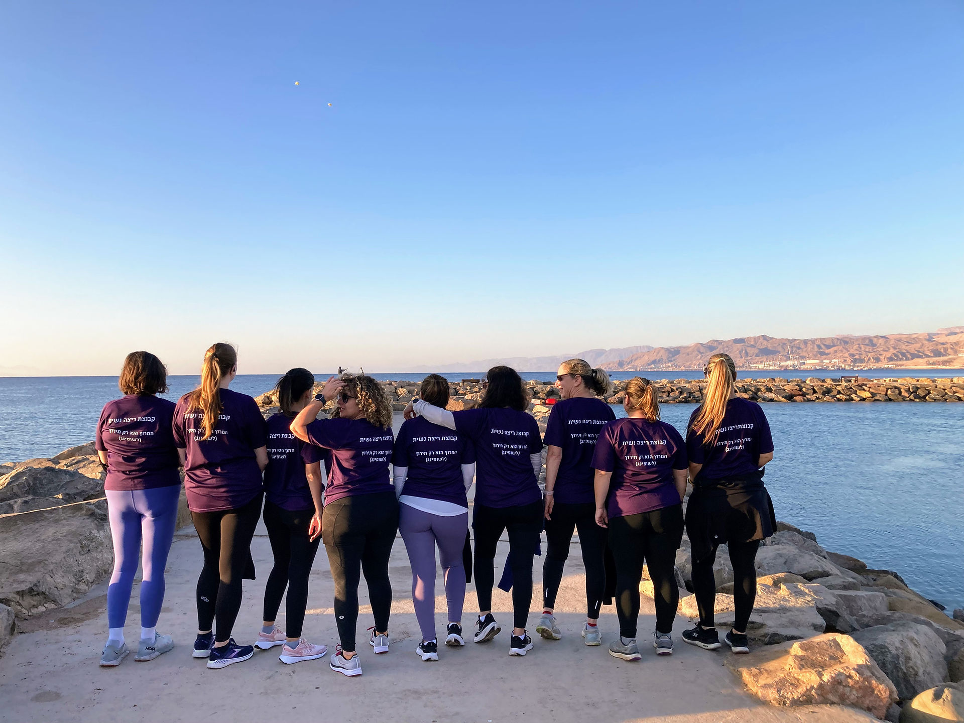 קבוצת ריצה נשית רגע לפני הזינוק - צילום מהגב