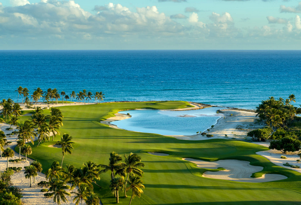 Lush fairways and manicured greens of Punta Espada Golf Course overlooking the sparkling ocean