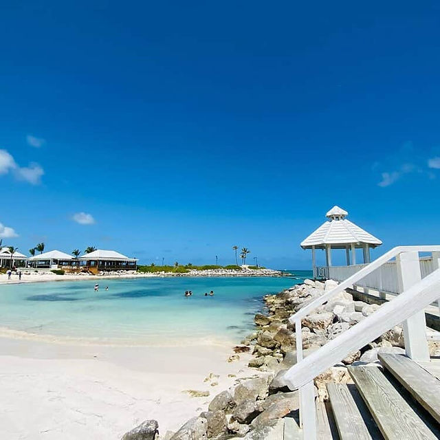 Scenic shot capturing the beach club’s pool area and the coastline from a mid-level vantage point.