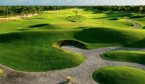 View of La Cana Golf Course featuring large mounds, devilish bunkers, and holes along the Caribbean Sea shoreline