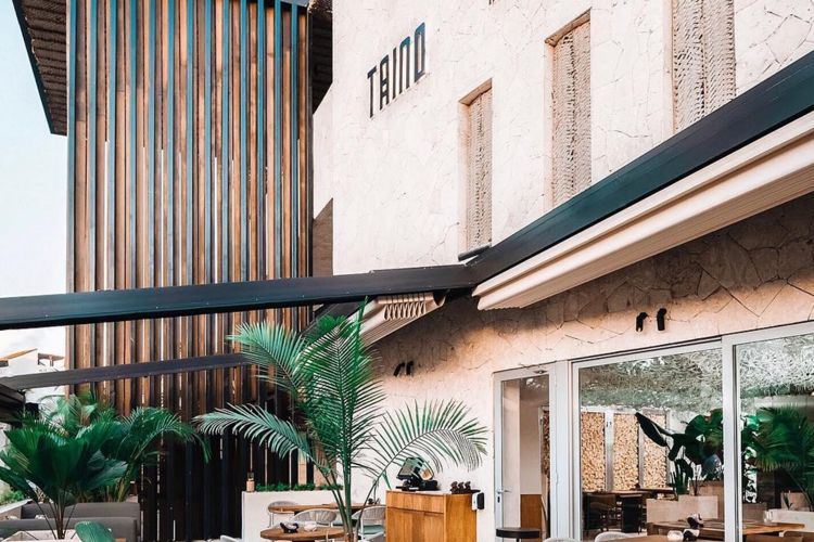 The outdoor seating area of Taino - Yopo Tiki Bar in Bávaro, surrounded by lush greenery and vibrant decor, creating a laid-back, tropical vibe.