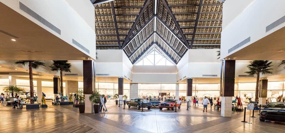 A bustling interior shot of BlueMall Puntacana, showcasing its upscale retail stores, vibrant atmosphere, and convenient location near Punta Cana International Airport