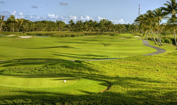 Golf course set in tropical landscape with abundant water views at Barcelo in Punta Cana