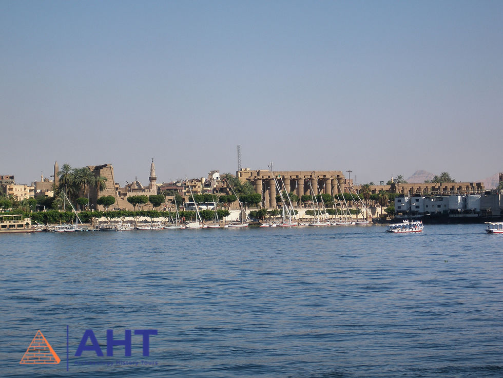 Luxor temple viewed from across the Nile River with sail boats docked on the shore