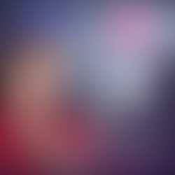 Professional freight dispatch instructor in red blouse holding a white flower, with dispatchers working at multiple computer monitors in a live training environment.