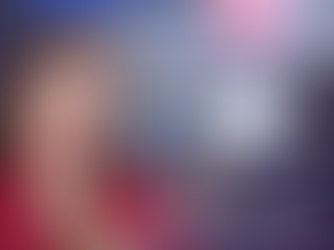 Professional freight dispatch instructor in red blouse holding a white flower, with dispatchers working at multiple computer monitors in a live training environment.