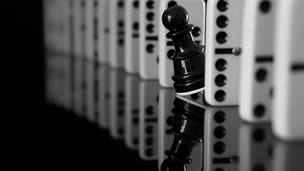 Black chess pawn holding firm among dominoes, symbolizing strategic partnership and stability.