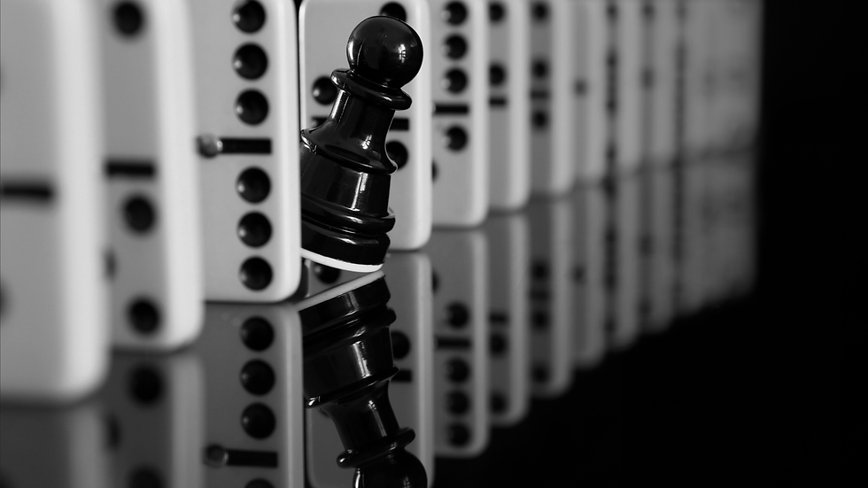 Black chess pawn holding firm among dominoes, symbolizing strategic partnership and stability.