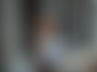 Architecte sur chantier tenant des plans devant une structure soutenue par de solides piliers en béton – Atelier d’Architecture Anne-Gaëlle VIAL.