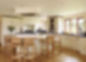 Modern kitchen with white cabinets, island, wood stools