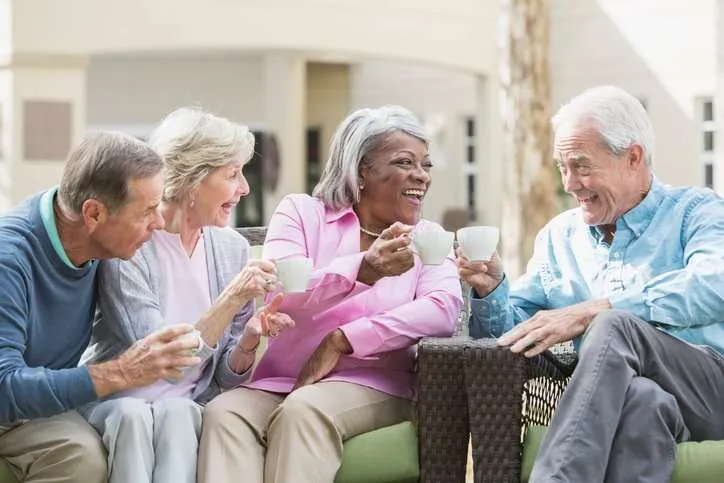 Senior man looking out of his New Jersey home window; Senior woman engaging in a group activity in a New Jersey nursing home