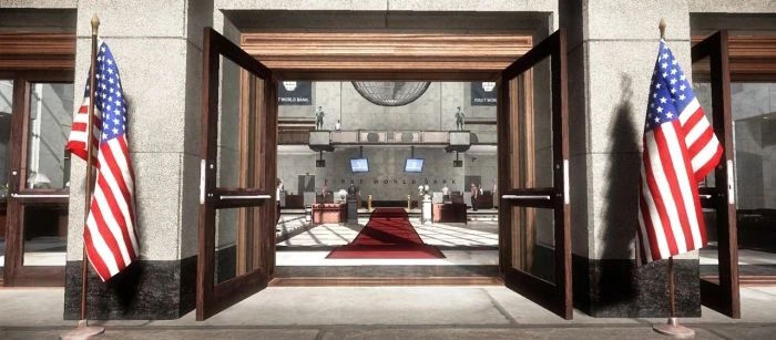 Open entrance doors to the First World Bank in Payday: The Heist, revealing the grand lobby adorned with American flags and a red carpet leading inside.