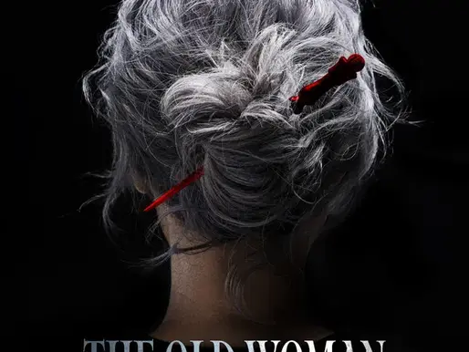 Back view of an older woman with messy silver hair tied in a loose bun. A small red knife is tucked into her hair like a hairpin. She stands against a black background, creating a dark, mysterious mood.
