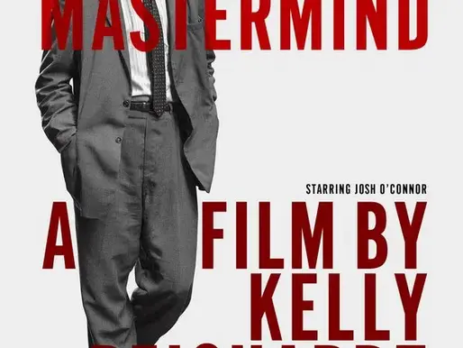 Official movie poster for The Mastermind (2025), directed by Kelly Reichardt. The poster features actor Josh O’Connor standing in a grey suit with a disheveled look, hands in pockets, gazing to the side. The title “THE MASTERMIND” appears in bold red letters across the image, along with the text “A FILM BY KELLY REICHARDT.” The design is minimalist, with a monochrome background and Cannes Film Festival laurels in the upper right corner.