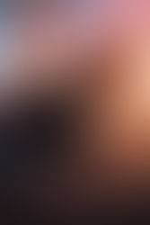 Vertical movie-poster style image of a GTA Online Stunt Race at sunset, featuring a race car with a large rear spoiler accelerating toward a steep orange ramp and massive loop structure, with multiple cars climbing the ramp under a dramatic pink and orange sky.