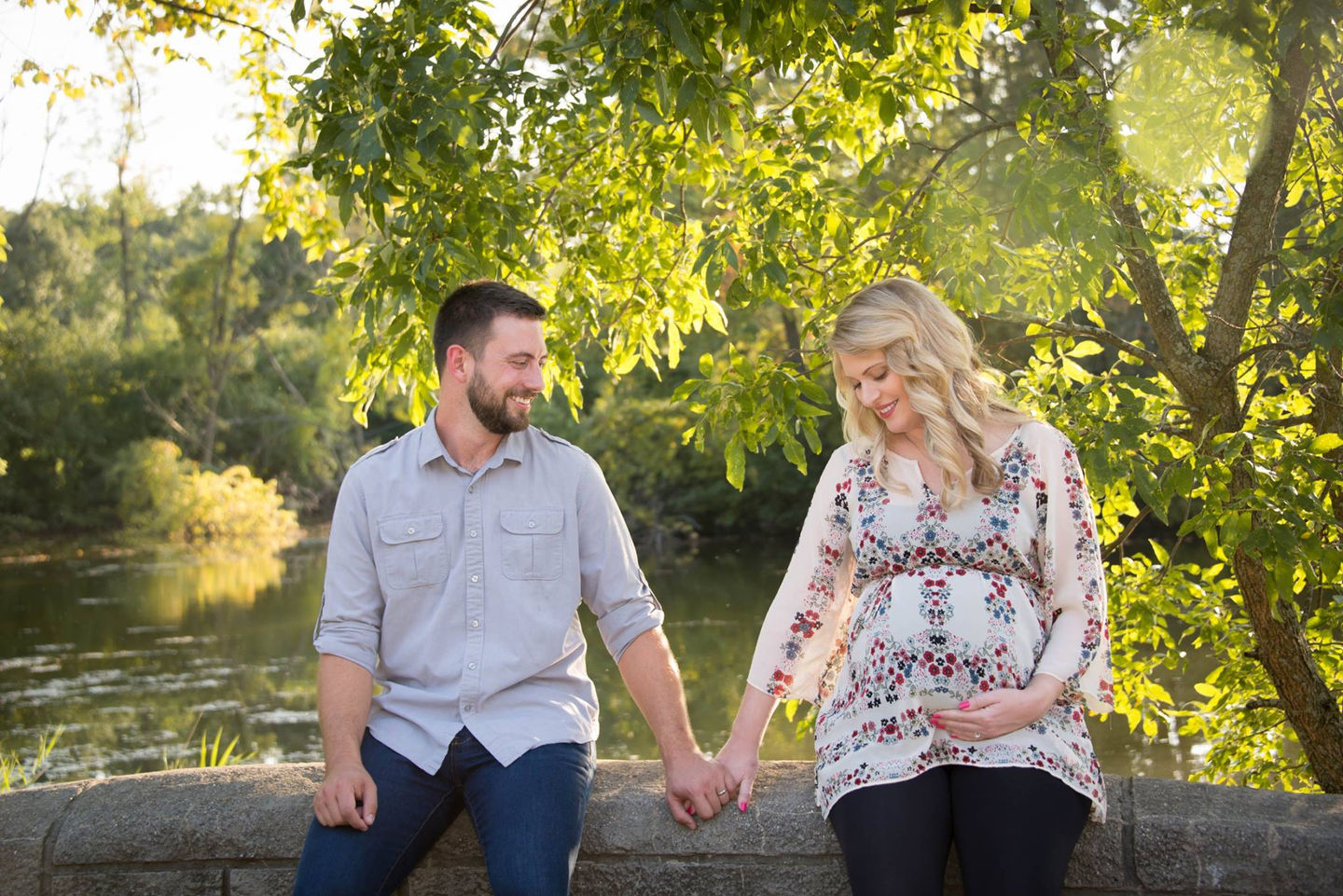 outdoor maternity portrait of a couple by a pond