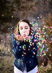 girl blowing confetti at her portrait birthday party