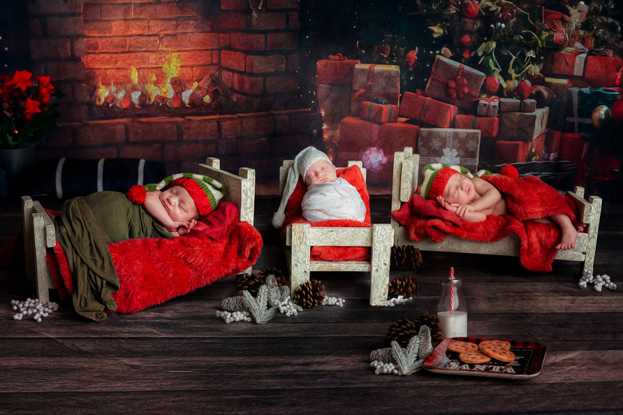Fine art pained Christmas scene of newborn triplets each laying in a little bed with milk and cookies at the front of the image