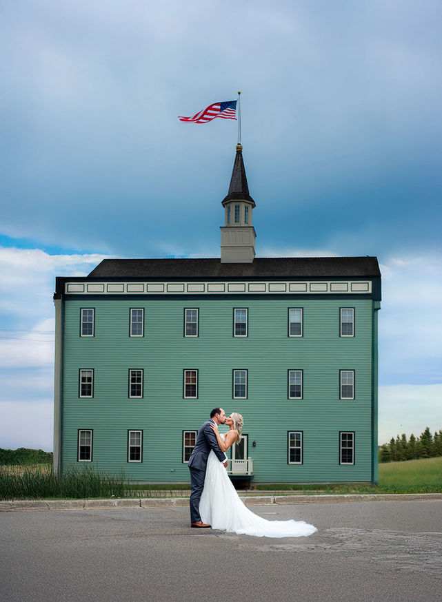bride and groom in front of an old Delafield building