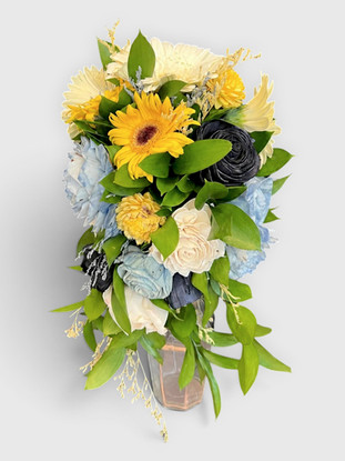 Cascading wood flower bridal bouquet featuring yellow daisies, blue and black roses, and green leaves.