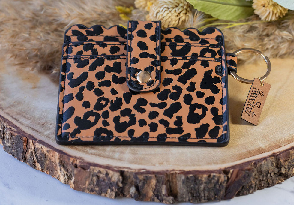 Cheetah print scallop card holder with snap closure, styled on wooden display with dried florals.