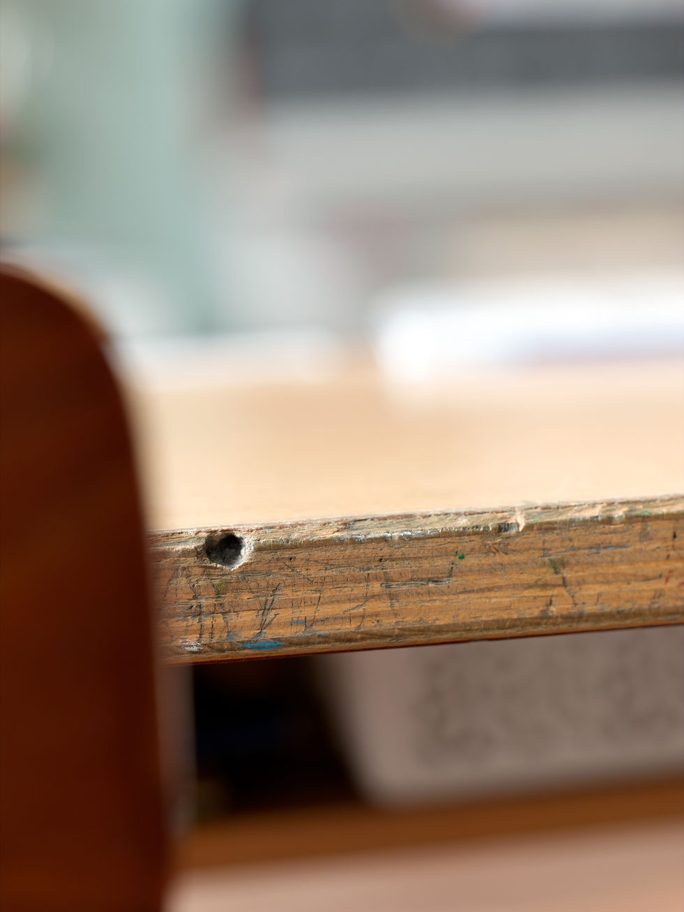 Loch in der Stirnseite des Schultisches