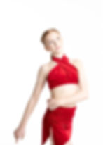 Dancer in red crisscross halter crop top and ruched wrap skirt.
