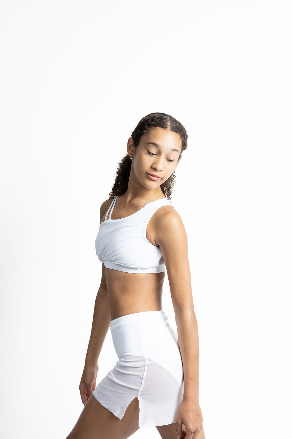 White one-shoulder ruched crop with sheer side-slit skirt on dancer.