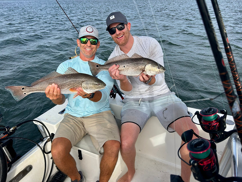 Two anglers with their red drum catch on a fishing boat in the sound of Outer Banks North Carolina
