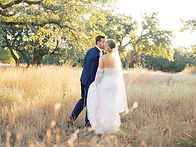 Bride and groom walking in field photographed by Austin wedding photographer Harper Blankenship