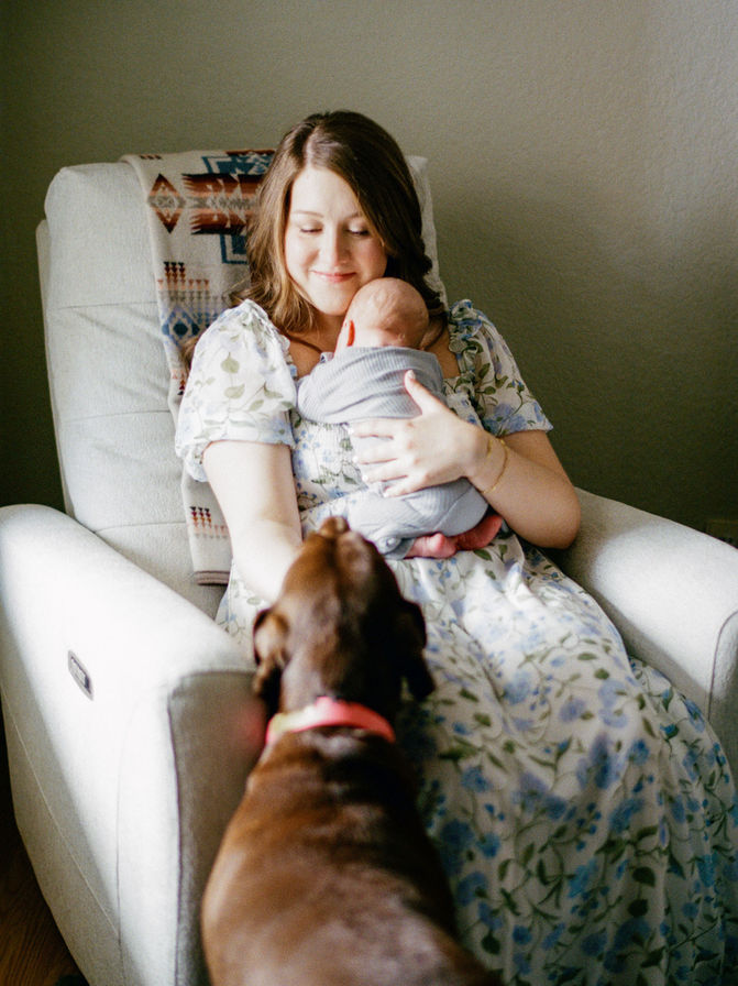 Austin newborn photographer capturing mother and newborn seated in nursery