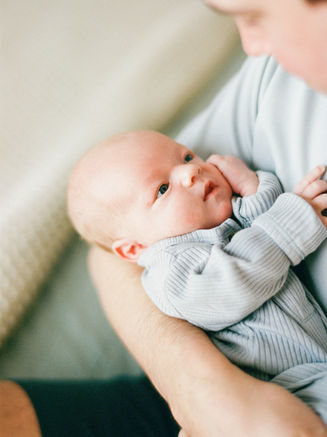Austin newborn photographer capturing baby resting in parent’s arms during lifestyle session