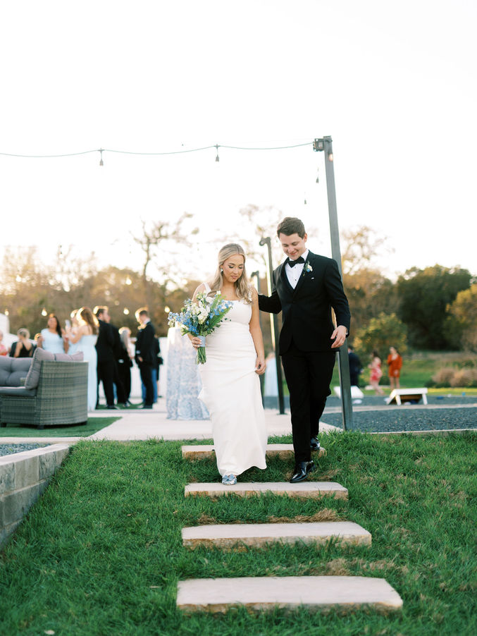 Bride and groom walking on ceremony lawn at Posey Meadows in San Marcos Texas