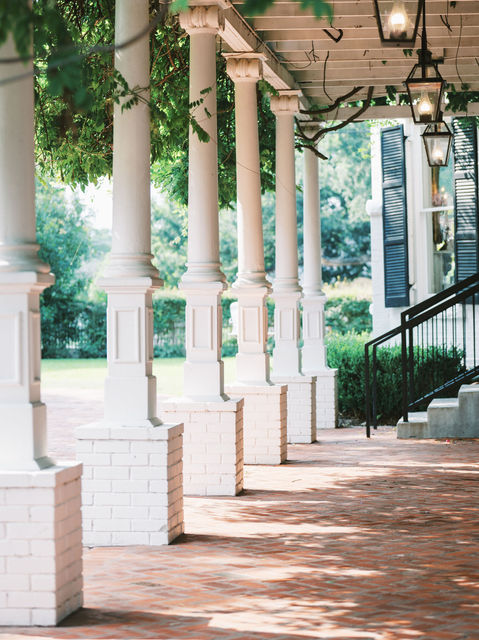 The white-columned veranda and brick walkway of Woodbine Mansion in Round Rock, Texas — iconic wedding venue architecture