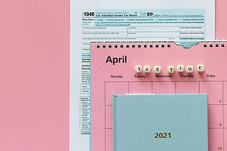 Federal Form 1040 Individual Income Tax Return with a calendar showing April tax time and a ledger all laying on top of form