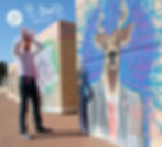 עטיפת האלבום ״בואו לפני״. צילום של ג׳ימבו ג׳יי עומד מול קיר שעליו ציור גראפיטי של החיה אייל לבושה בחליפה עסקית. ג׳ימבו בלבוש עסקי עם עניבה ורודה ומבצע בידיו תנועה של קרניים מעל ראשו.